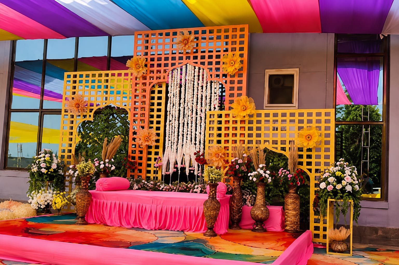 Colourful mehendi sangeet stage with pink seating and lattice backdrop by Nilesh Decorators Neral