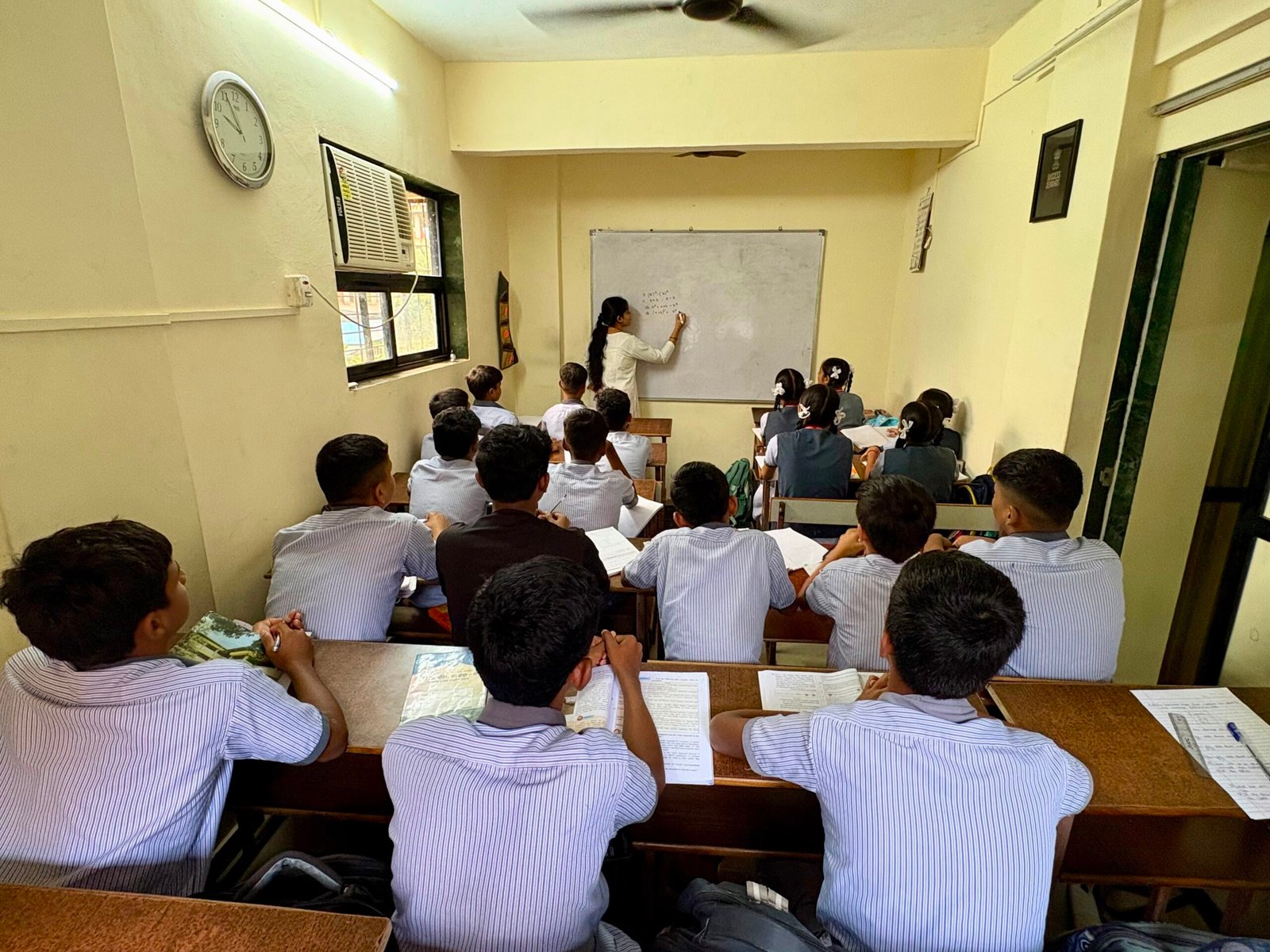 Teacher explaining a maths problem on the whiteboard at Success Educare Classes Neral, Karjat taluka